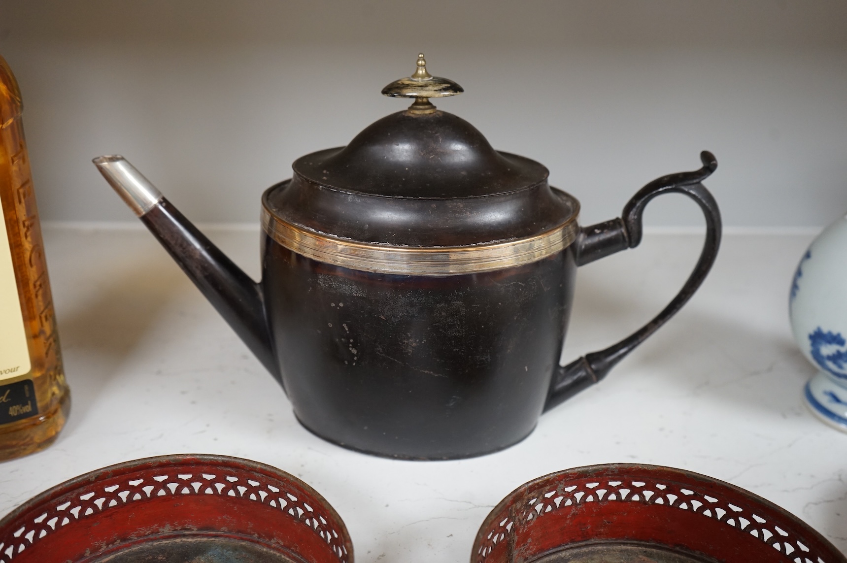 A George III silver and Old Sheffield plate mounted toleware teapot and a pair of red japanned toleware wine coasters, teapot 28cm wide (3)